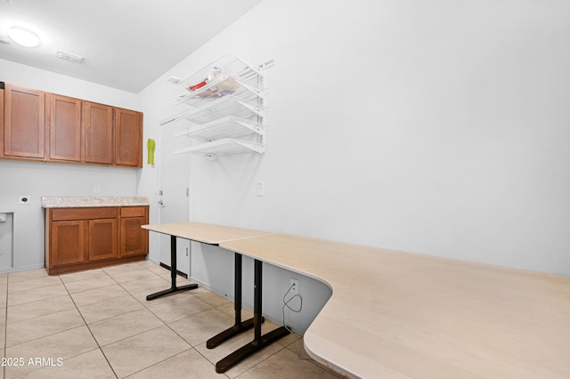 interior space featuring cabinets, light tile patterned floors, and electric dryer hookup