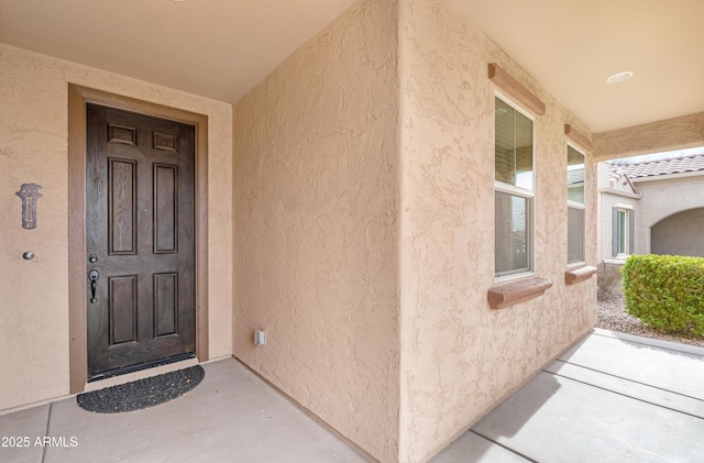 view of exterior entry featuring covered porch