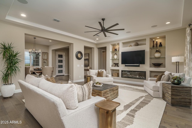 26673 W Ponderosa Ln, Buckeye, AZ 85396 - living room featuring built in features, a tray ceiling, wood finished floors, and ceiling fan with notable chandelier