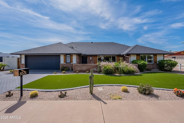 single story home featuring brick siding, driveway, a front yard, and a garage