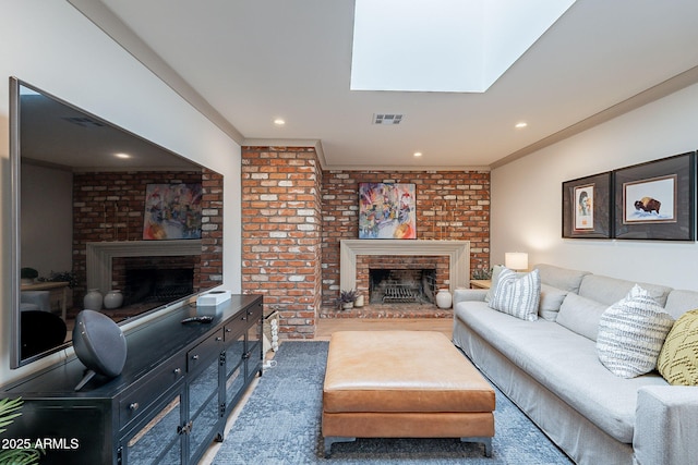 living area with a brick fireplace, visible vents, and recessed lighting