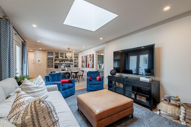living room featuring an inviting chandelier, built in features, a skylight, and recessed lighting