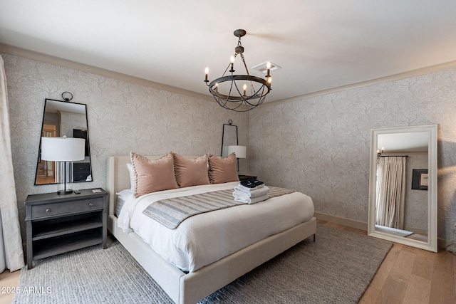 bedroom featuring wood finished floors and an inviting chandelier