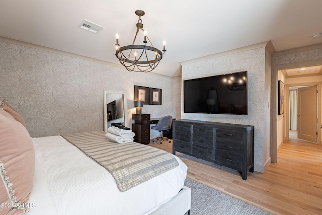 bedroom with a chandelier, wood finished floors, and visible vents