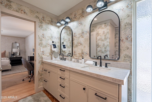 full bathroom with wallpapered walls, ensuite bathroom, wood finished floors, and a sink
