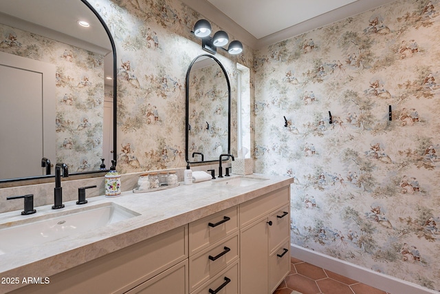 bathroom with wallpapered walls, tile patterned floors, baseboards, and a sink