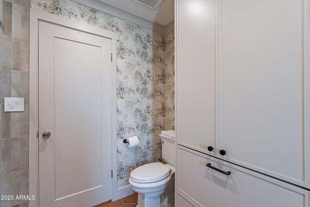 bathroom featuring toilet, tile patterned flooring, and wallpapered walls