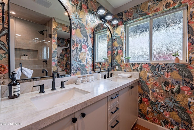bathroom featuring wallpapered walls, visible vents, and a sink