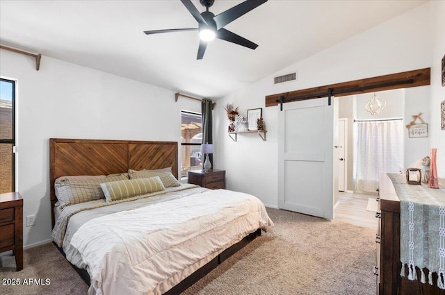 bedroom with visible vents, vaulted ceiling, light colored carpet, a barn door, and a ceiling fan