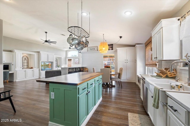 kitchen with wood counters, a center island, decorative light fixtures, white cabinetry, and green cabinets