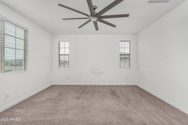 empty room with ceiling fan, plenty of natural light, and light carpet