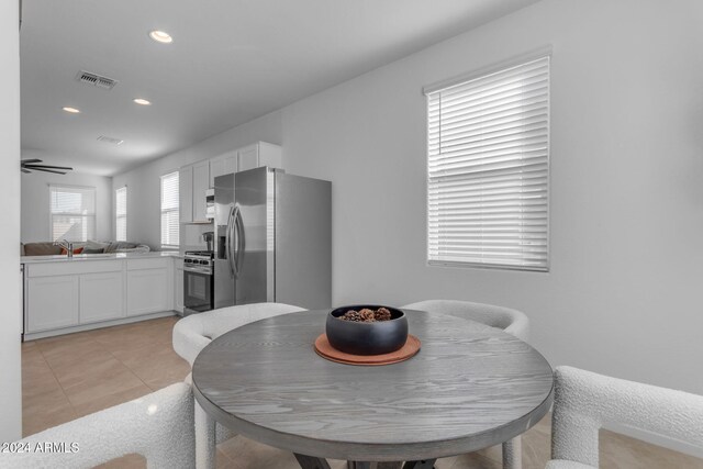 dining space featuring ceiling fan, sink, and light tile patterned floors