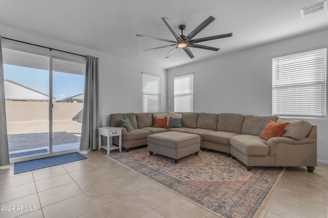 tiled living room with plenty of natural light and ceiling fan