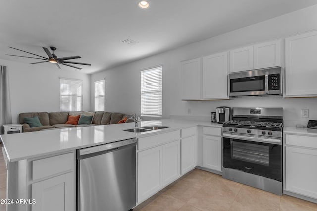 kitchen featuring kitchen peninsula, stainless steel appliances, white cabinets, and sink