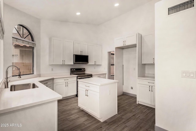 kitchen with visible vents, a sink, dark wood finished floors, stainless steel appliances, and white cabinets