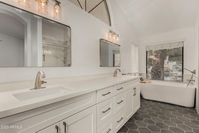 full bathroom featuring tile patterned flooring, double vanity, a stall shower, and a sink