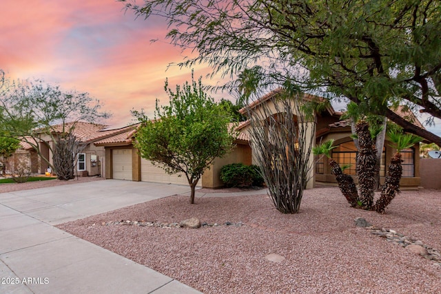 view of front of house with stucco siding, roof mounted solar panels, concrete driveway, an attached garage, and a tiled roof