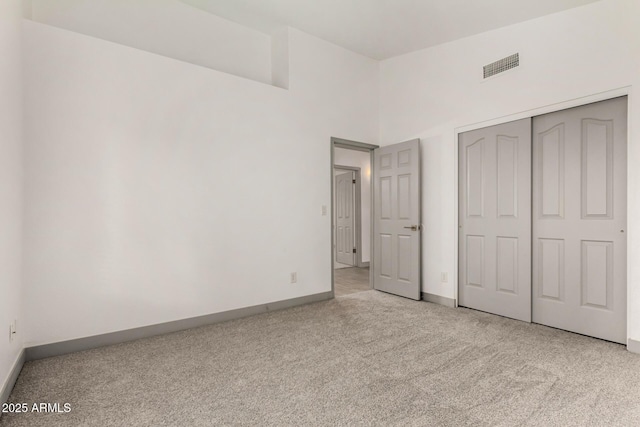 unfurnished bedroom featuring a closet, visible vents, carpet flooring, and baseboards