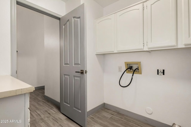 washroom with baseboards, cabinet space, hookup for a washing machine, and wood tiled floor