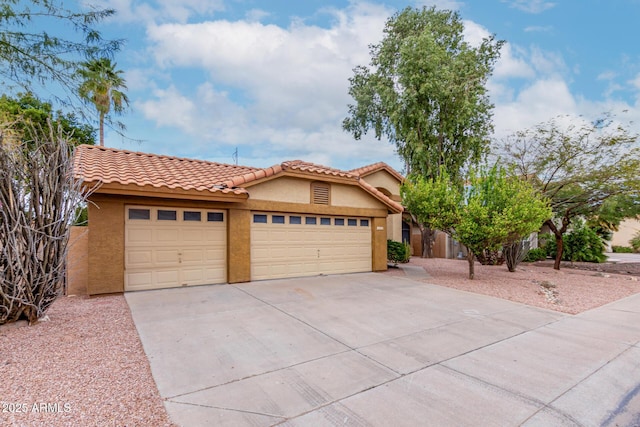 view of front facade with stucco siding, concrete driveway, an attached garage, and a tiled roof