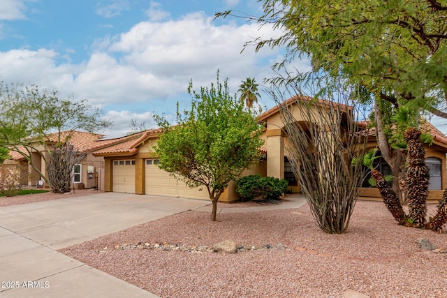 view of front facade featuring stucco siding, an attached garage, a tile roof, and concrete driveway