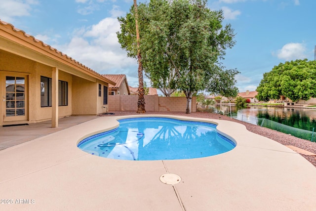 view of pool with a fenced in pool, a water view, a fenced backyard, and a patio area