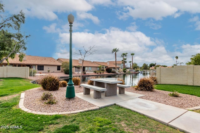 view of yard featuring a patio area, fence, a water view, and a residential view