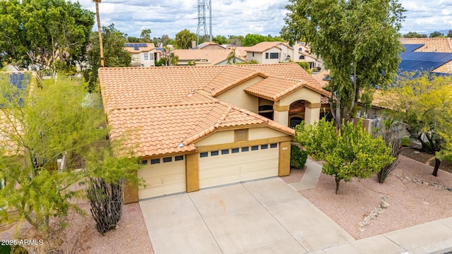 mediterranean / spanish-style house featuring a tile roof, an attached garage, driveway, and stucco siding