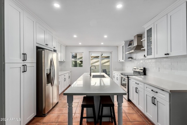 kitchen with white cabinetry, light tile patterned floors, wall chimney range hood, and appliances with stainless steel finishes