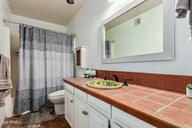 full bathroom with vanity, shower / bath combo, and toilet