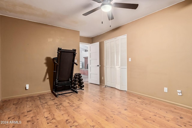 exercise area with light wood-type flooring and ceiling fan