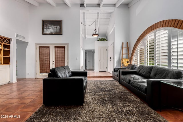 tiled living room featuring beam ceiling, french doors, and high vaulted ceiling