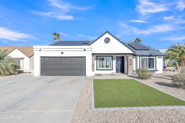 ranch-style home with solar panels and a garage