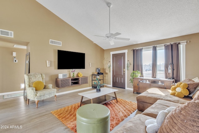 living room with ceiling fan, high vaulted ceiling, a textured ceiling, and light wood-type flooring