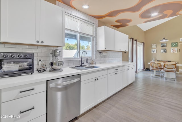 kitchen featuring decorative backsplash, stainless steel dishwasher, vaulted ceiling, sink, and light hardwood / wood-style floors