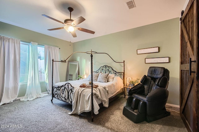 bedroom featuring a barn door, ceiling fan, and carpet floors