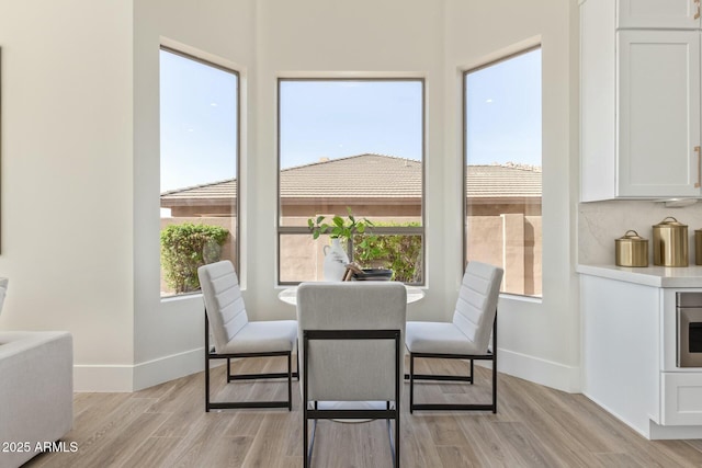 dining area featuring light wood-type flooring and baseboards