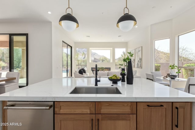 kitchen featuring open floor plan, a wealth of natural light, a sink, and a center island with sink