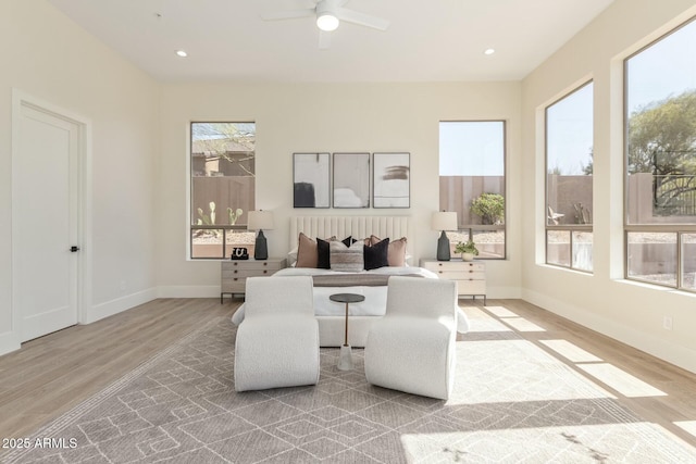 living area with light wood-style floors, recessed lighting, ceiling fan, and baseboards