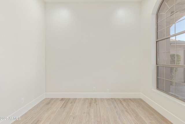 unfurnished room featuring baseboards and wood finished floors