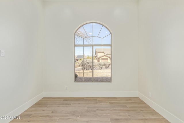 unfurnished room featuring light wood finished floors and baseboards