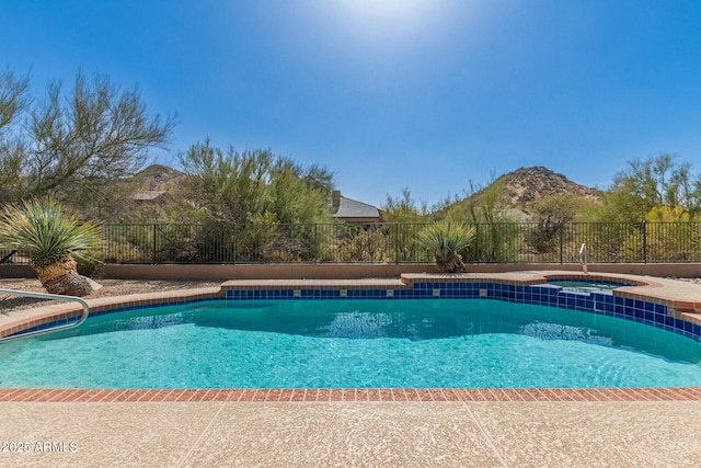 view of pool featuring an in ground hot tub, fence, a mountain view, and a fenced in pool