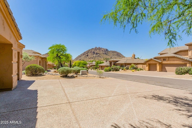 view of patio with a garage, a residential view, and a mountain view