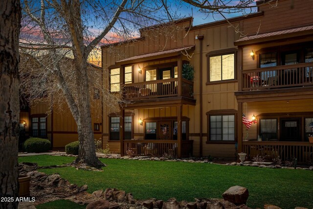 2361 Quarter Horse Trl Unit 232, Overgaard, AZ 85933 - rear view of house with board and batten siding, a porch, a lawn, and a balcony