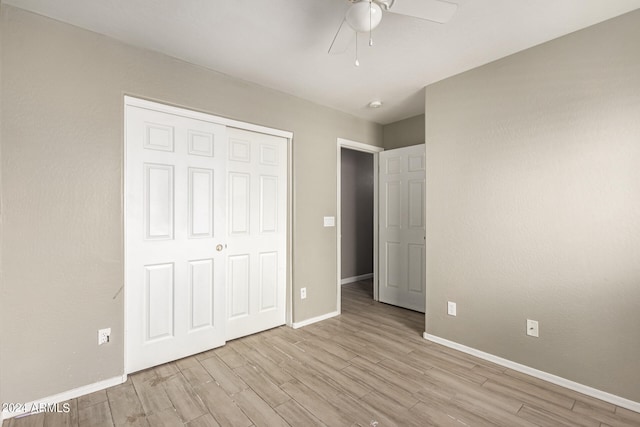 unfurnished bedroom with a closet, light hardwood / wood-style floors, and ceiling fan