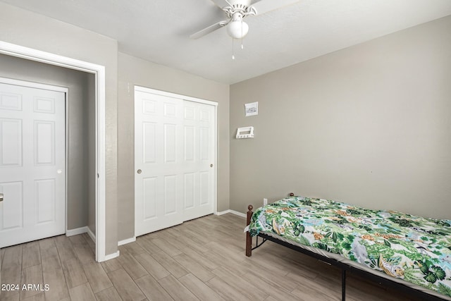 bedroom with ceiling fan, a closet, and light hardwood / wood-style floors