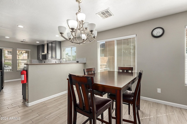 dining area featuring an inviting chandelier, light hardwood / wood-style flooring, and a healthy amount of sunlight