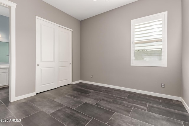 13850 W Weaver Ct, Litchfield Park, AZ 85340 - unfurnished bedroom with a closet, baseboards, and connected bathroom