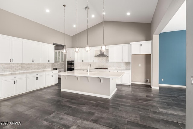 13850 W Weaver Ct, Litchfield Park, AZ 85340 - kitchen featuring high vaulted ceiling, light countertops, an island with sink, white cabinetry, and decorative light fixtures