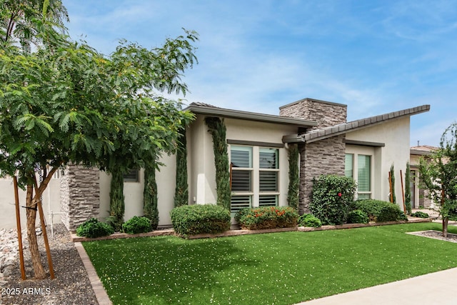 13850 W Weaver Ct, Litchfield Park, AZ 85340 - view of front of house with stucco siding, a front lawn, a chimney, and stone siding